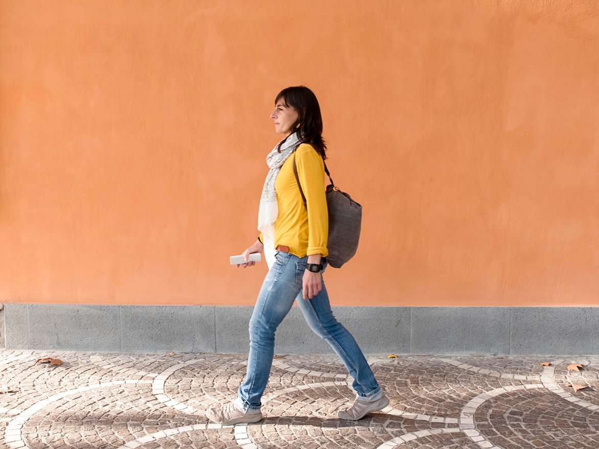 Side View of a Traveler Walking against Orange Wall 